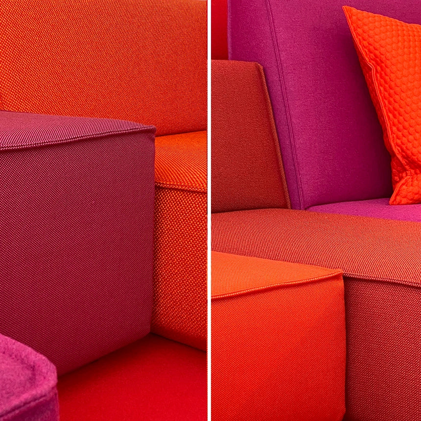 Nahaufnahme zweier unterschiedlich kombinierter Sofaecken mit intensiven Stofffarben und klarer Textur, die modulare Bauweise und Farbvielfalt des Sofas hervorhebend