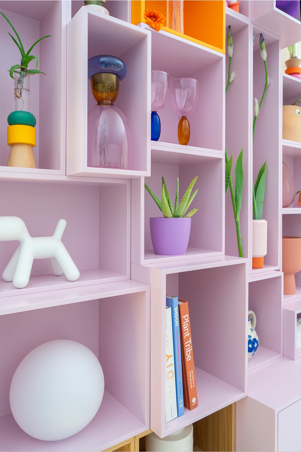 Cubit Regal in pastellfarbenem Rosa, bestückt mit Vasen, Pflanzen, Gläsern und Büchern in farbenfroher, dekorativer Anordnung