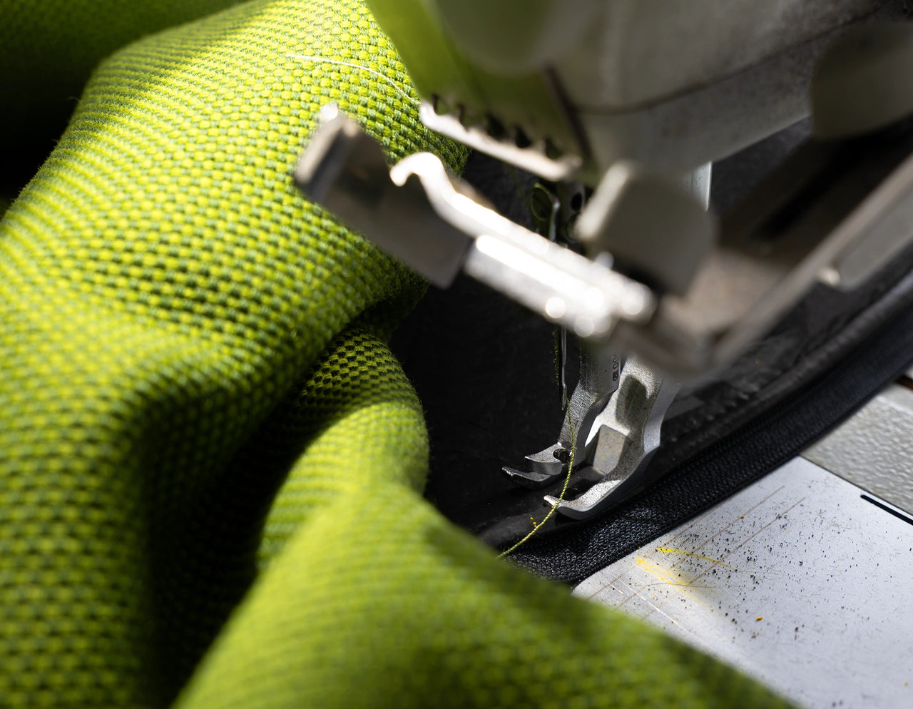 Close-up of a sewing machine processing a textured upholstery fabric - insight into Cubit's own sewing shop