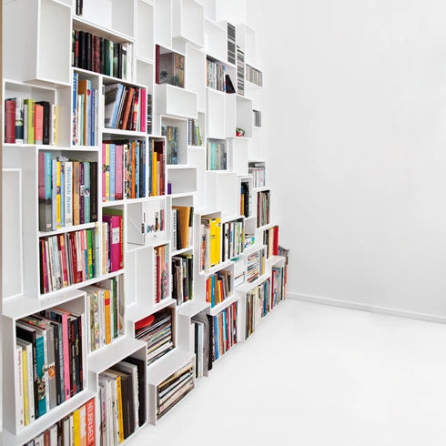 Bücherregal in Weiß, modern und minimalistisch, gefüllt mit Büchern und Magazinen.