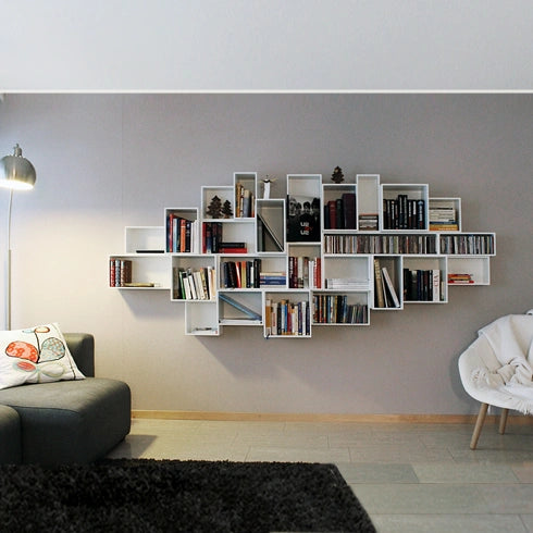 Weißes Hängeregal, modern gestaltet, kombiniert mit Büchern und einem Sofa.
