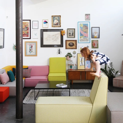 Modulares Sofa in bunten Farben, kombiniert mit einer dekorativen Wandgestaltung.