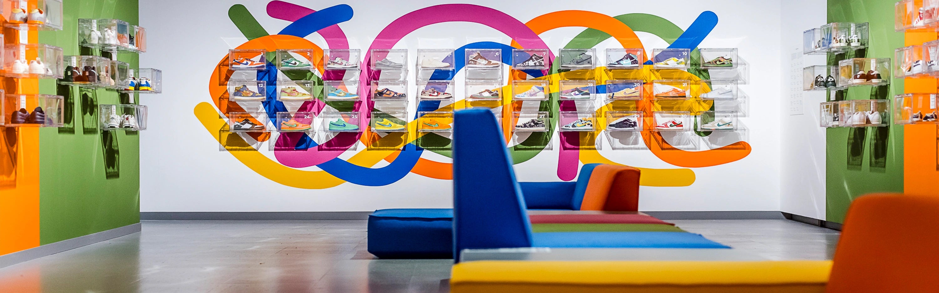 Colorful seating modules in the showroom with sneakers on the wall - design with modern contract furniture