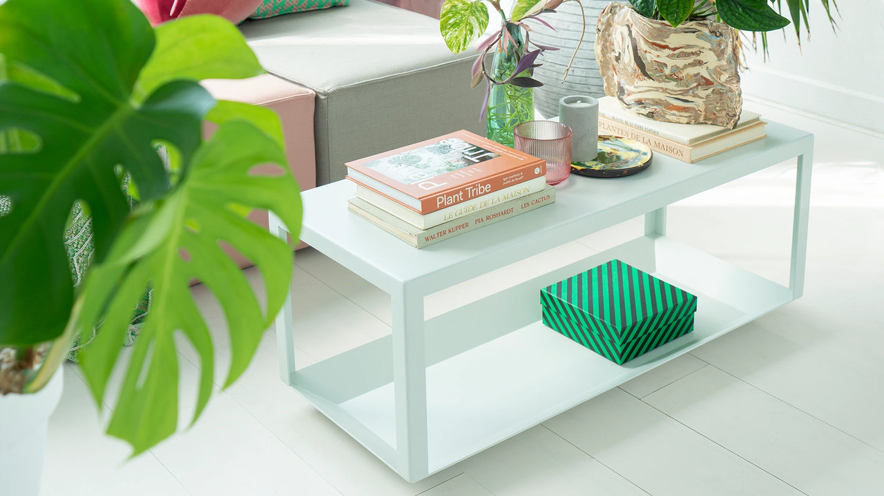 White minimalist coffee table with books, plant and decoration in the bright living room in front of a Cubit sofa
