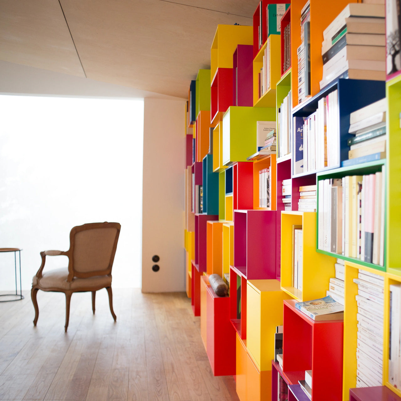Generous shelving wall with numerous modules for book storage, individually planned and designed in a variety of colors