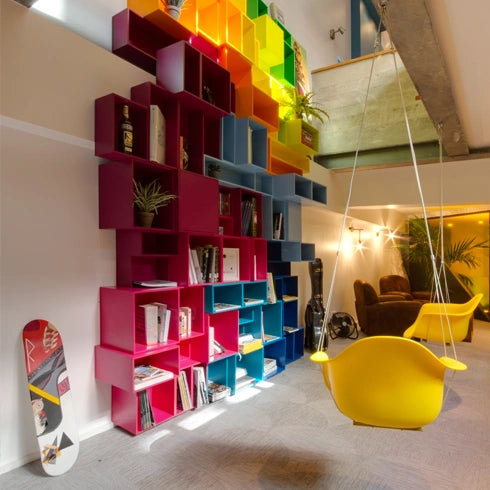 Colorful modular shelves in pink, blue and yellow, combined with a swing and plants.