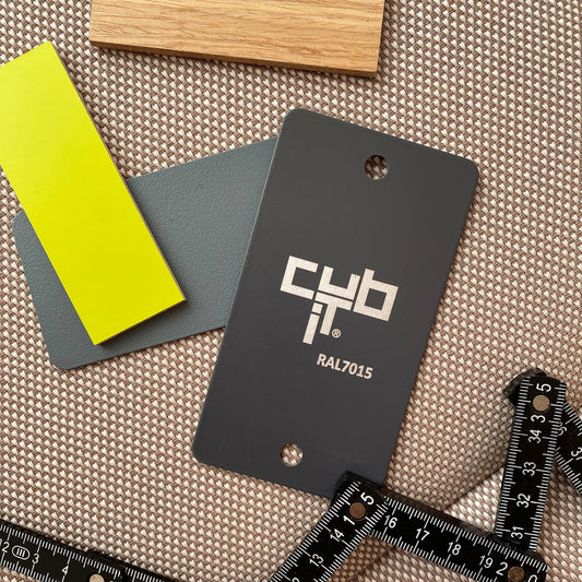 Material samples in wood, yellow and grey tones (RAL7015) on a fabric background with a ruler – for customer consultation