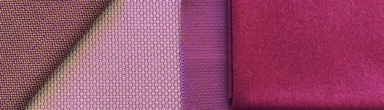 Various fabric samples in shades of purple, laid side by side and carefully folded, show different types of fabric