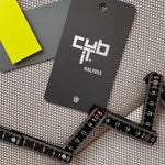Color sample in yellow and grey (RAL7015) with measuring tape on textile surface 