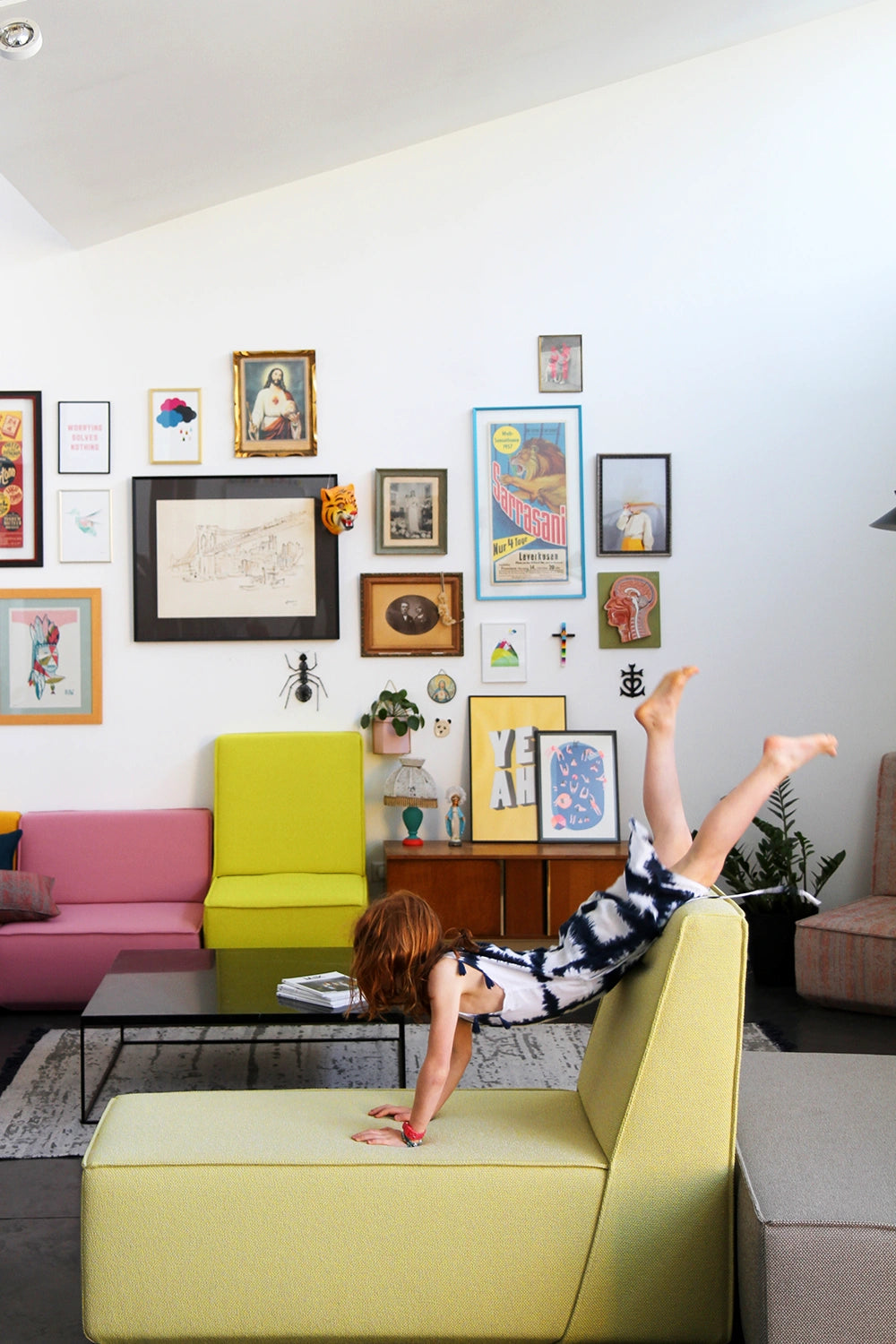 Child plays on a modular Cubit sofa in a creatively designed living room with colorful murals