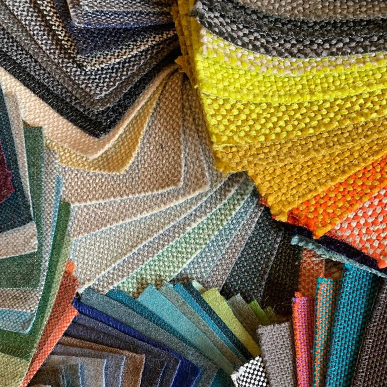 Panoramica dei numerosi campioni di tessuto tra cui scegliere per il divano Cubit , ordinati per sfumature di colore e texture